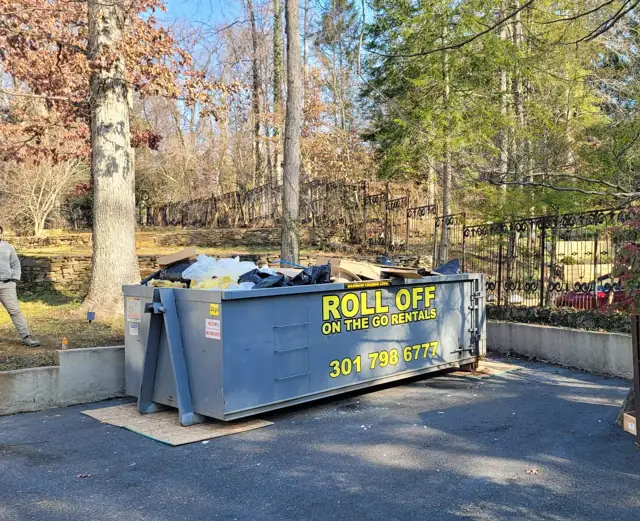 Roll Off On The Go container loaded with cleanout bags and boxes on a driveway in Bethesda, MD
