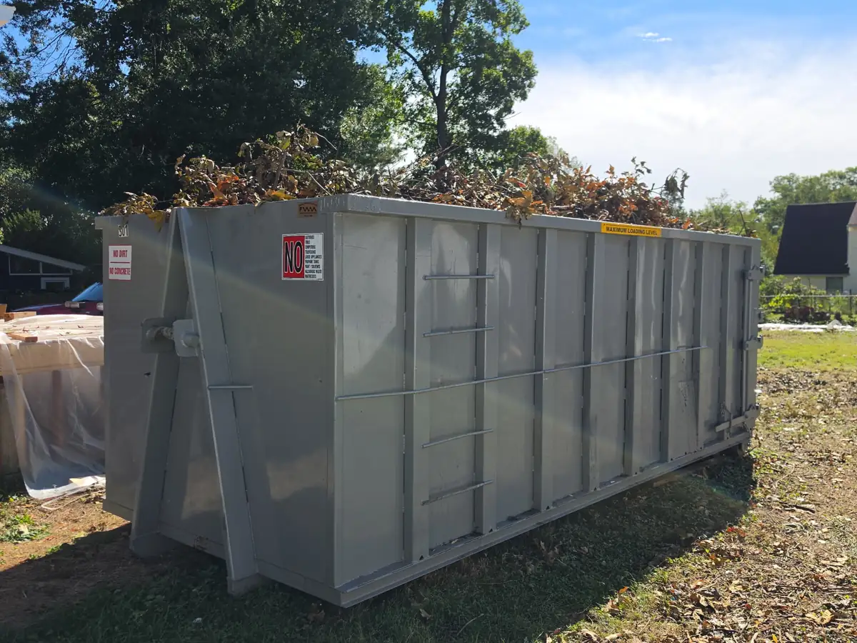 Tall roll off container filled with branches and yard debris at a home in Gaithersburg, MD